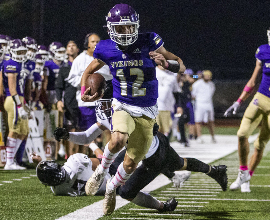 Lake Stevens’ Kolton Mason runs the ball down the sideline during the game against Eastlake on Friday, Oct. 7, 2022 in Lake Stevens, Washington. (Olivia Vanni / The Herald)
