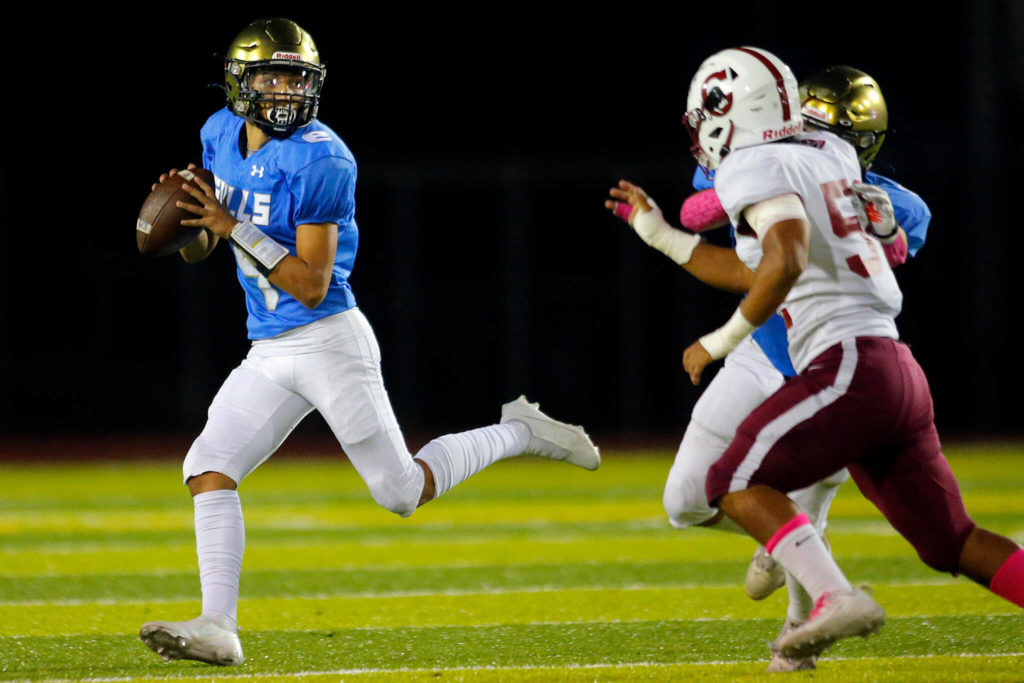 Everett quarterback Mauricio Garcia-Luna extends the play with his legs before connecting on a deep ball during the Battle of Broadway against Cascade on Friday, Oct. 7, 2022, at Everett Memorial Stadium in Everett, Washington. (Ryan Berry / The Herald)
