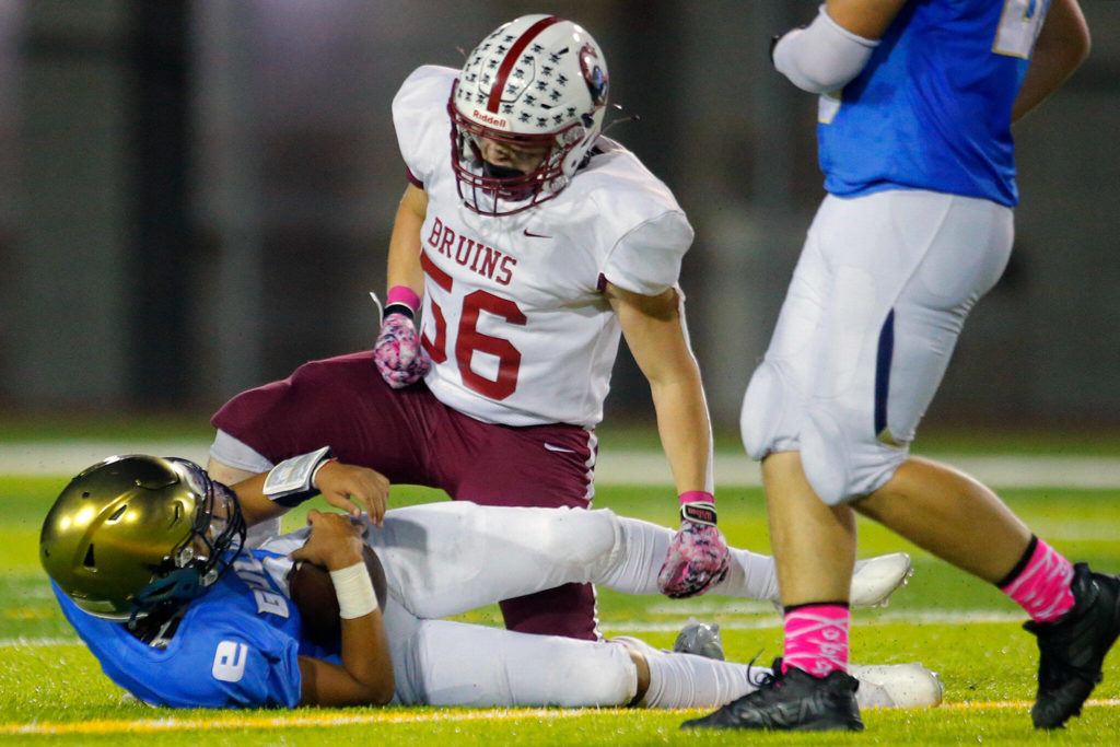 Cascade’s Colby Perman-Marshall stands over the Everett quarterback after sacking him during the Battle of Broadway against Everett on Friday, Oct. 7, 2022, at Everett Memorial Stadium in Everett, Washington. (Ryan Berry / The Herald)
