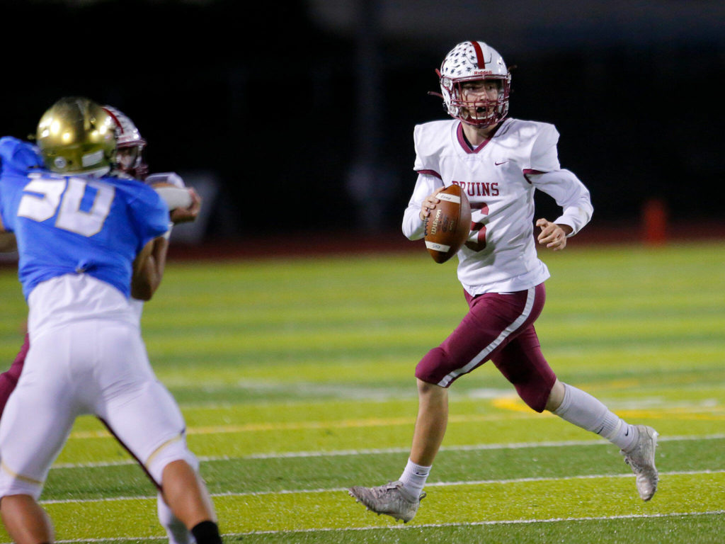 Cascade quarterback Eric Sowards rolls out of the pocket while looking downfield for a pass during the Battle of Broadway against Everett on Friday, Oct. 7, 2022, at Everett Memorial Stadium in Everett, Washington. (Ryan Berry / The Herald)
