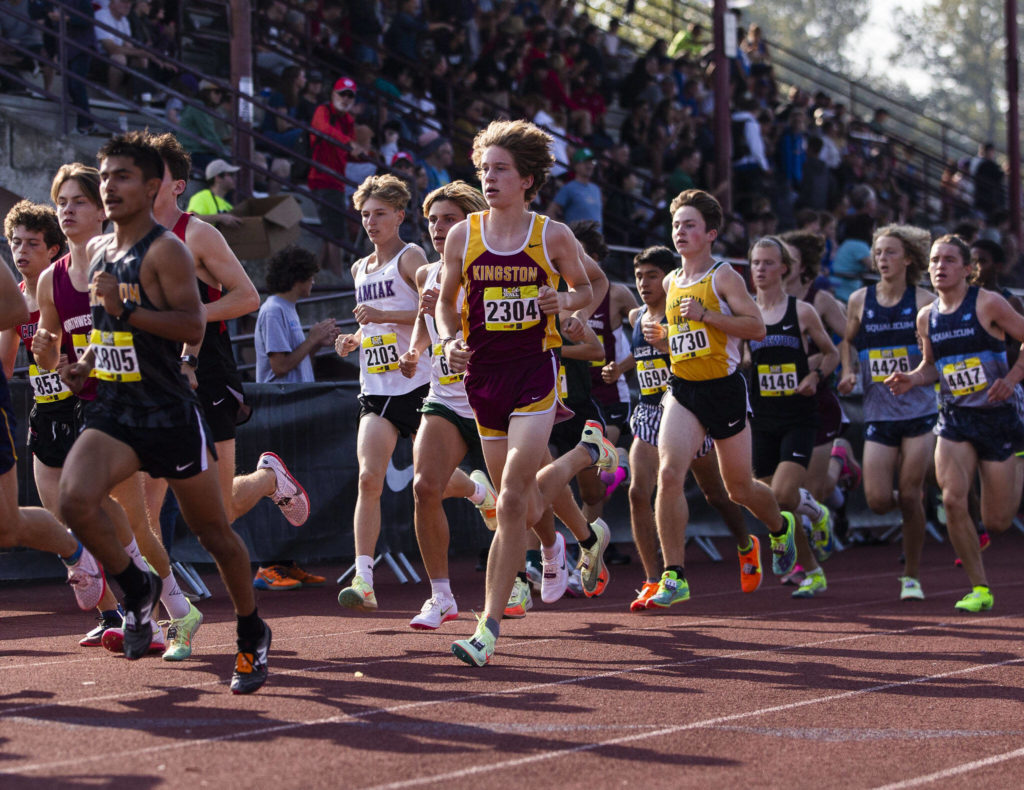 Boys varsity gold runners make their way off of the track during their first lap at the Hole In The Wall Invitational on Saturday, Oct. 8, 2022 in Arlington, Washington. (Olivia Vanni / The Herald)
