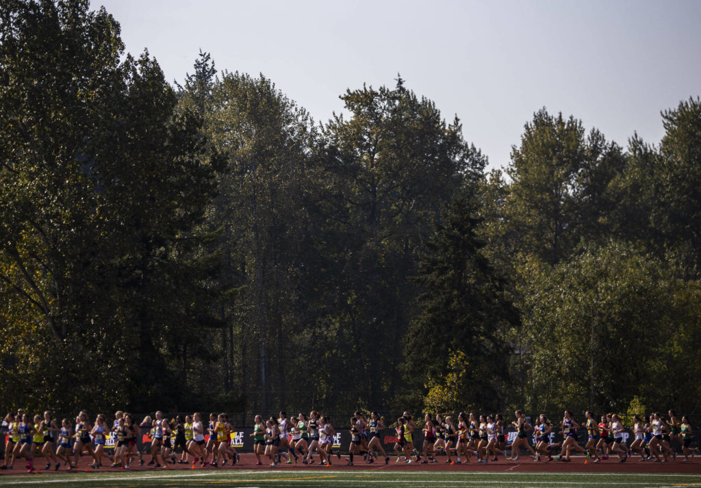 Runners make their way around the corner of the track at the Hole In The Wall Invitational on Saturday, Oct. 8, 2022 in Arlington, Washington. (Olivia Vanni / The Herald)
