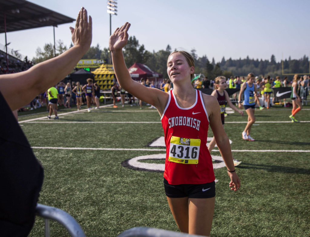 A Snohomish runner high fives a friend after finishing her race at the Hole In The Wall Invitational on Saturday, Oct. 8, 2022 in Arlington, Washington. (Olivia Vanni / The Herald)
