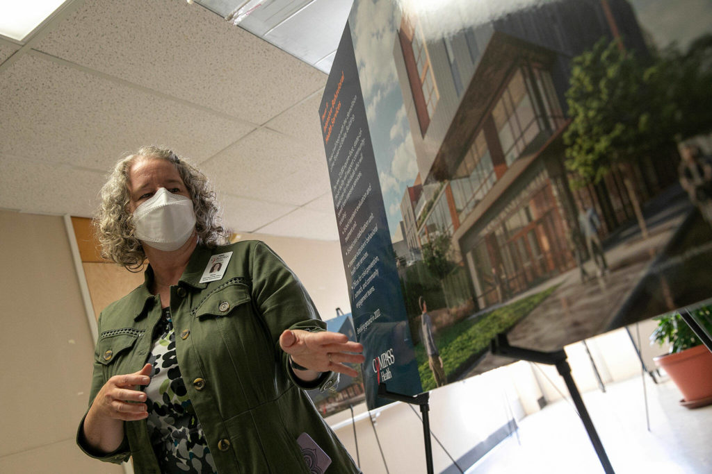 Stacey Alles, Compass Health chief operating officer, talks about the benefits of the future Compass Health Broadway building during a tour inside its current Broadway facility Wednesday in Everett. (Ryan Berry / The Herald)
