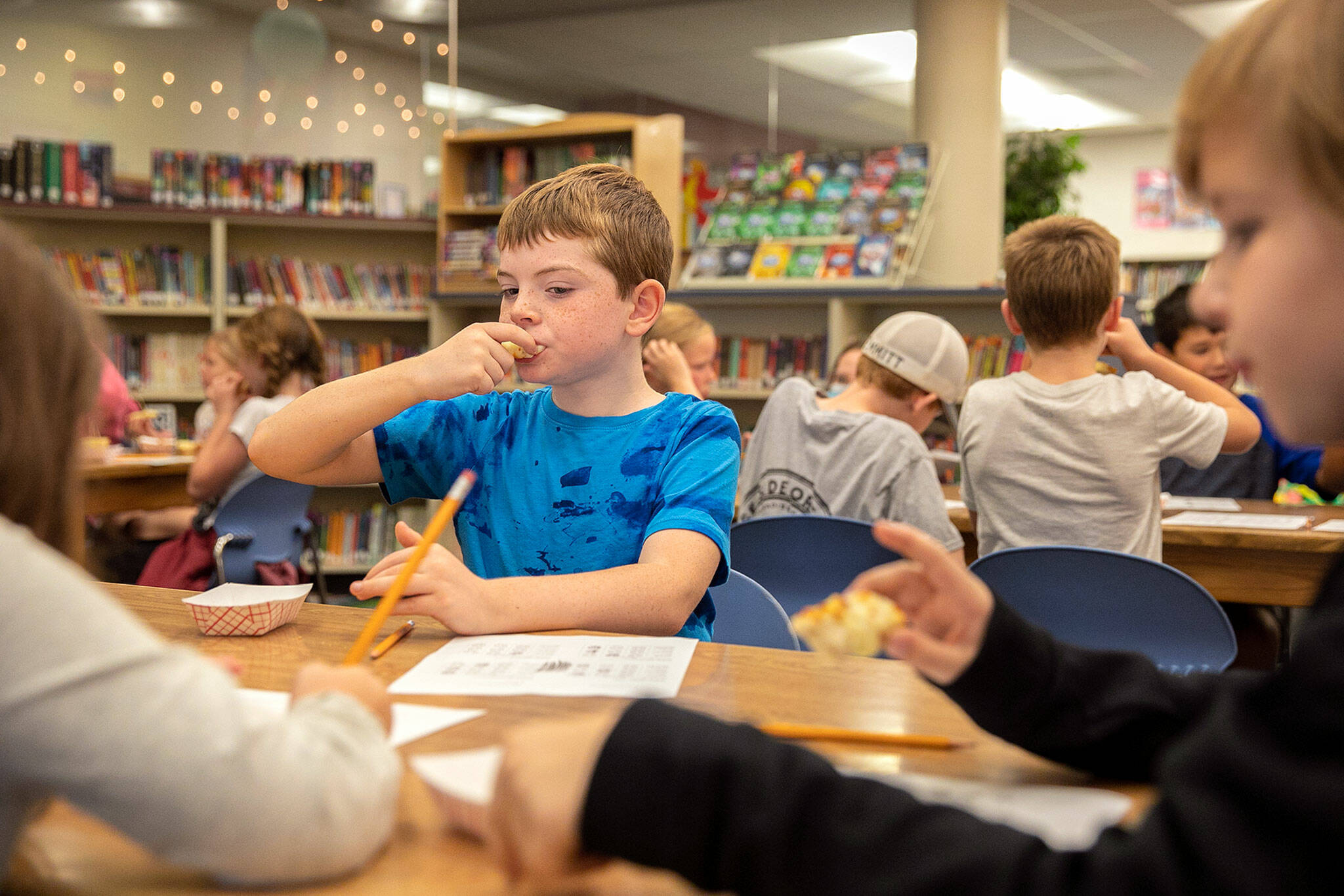 Third grader Finley Perrigo takes a bite of garlic bread while tasting four different samples alongside classmates Tuesday, at Eagle Creek Elementary, in Arlington. (Ryan Berry / The Herald)