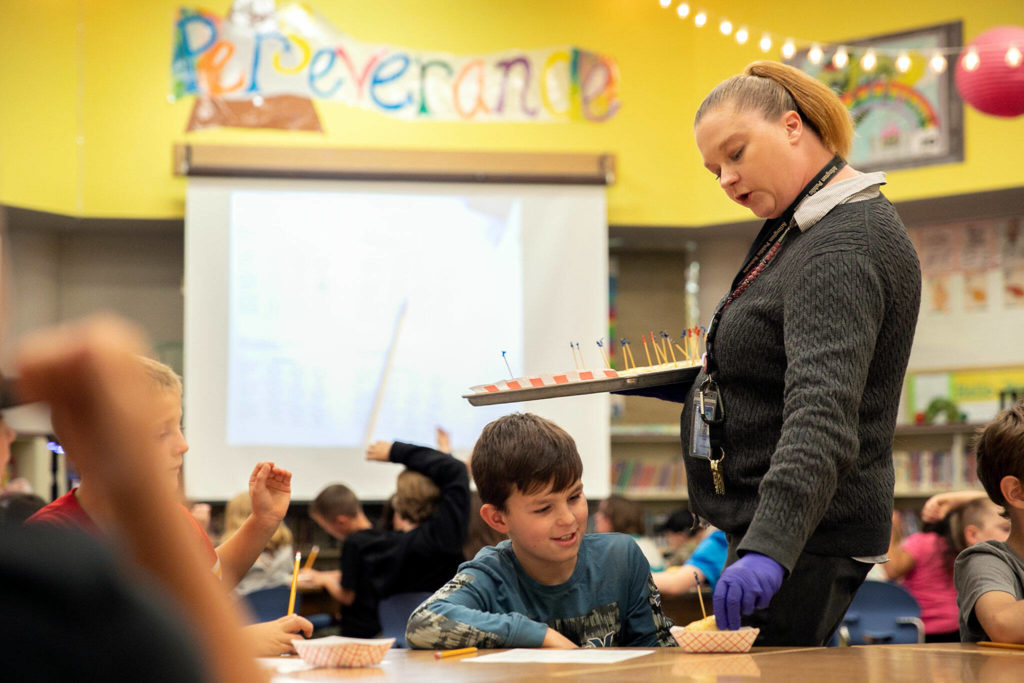 Kristen Satra, assistant supervisor of child nutrition for Arlington Schools, hands out samples of garlic bread during a taste test Tuesday, at Eagle Creek Elementary, in Arlington. (Ryan Berry / The Herald)
