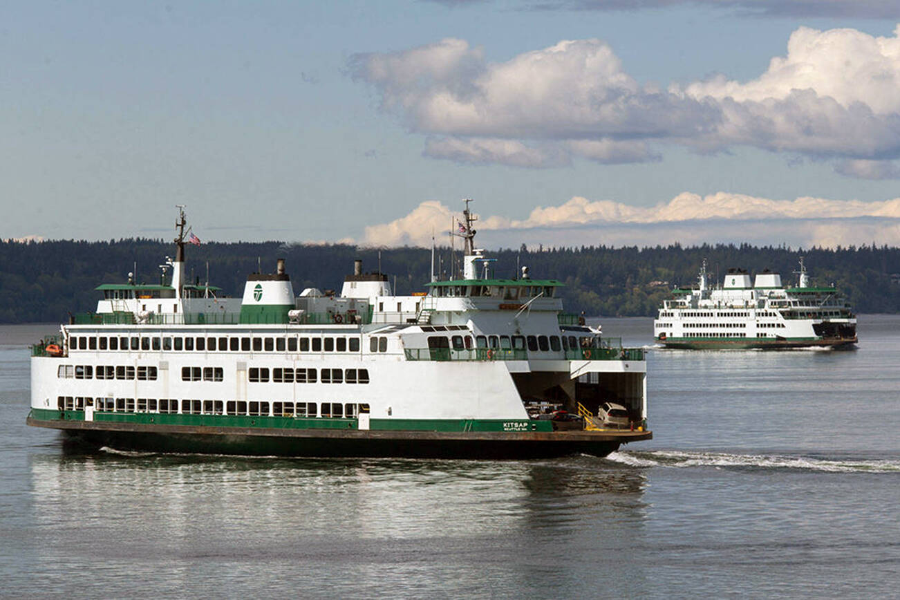 Ferries pass on a crossing between Mukilteo and Whidbey Island. (Andy Bronson / Herald file)