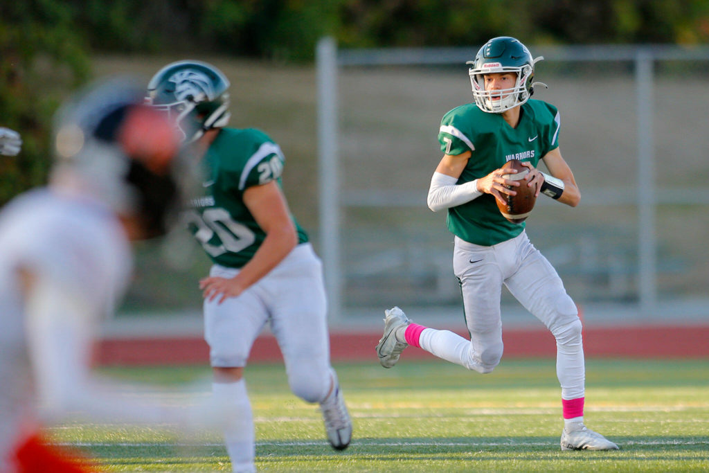 Edmonds-Woodway’s Steven Warren Jr. rolls out of the pocket while looking to pass against Monroe on Friday, Oct. 14, 2022, at Edmonds School District Stadium in Edmonds, Washington. (Ryan Berry / The Herald)
