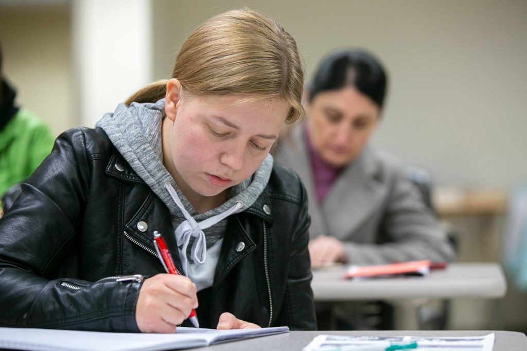 Antonina Chubara, who fled Ukraine in the spring and came to Washington with her older sister, practices the present simple verb tense in an ESL class at Everett Community College on Monday, in Everett. (Ryan Berry / The Herald)
