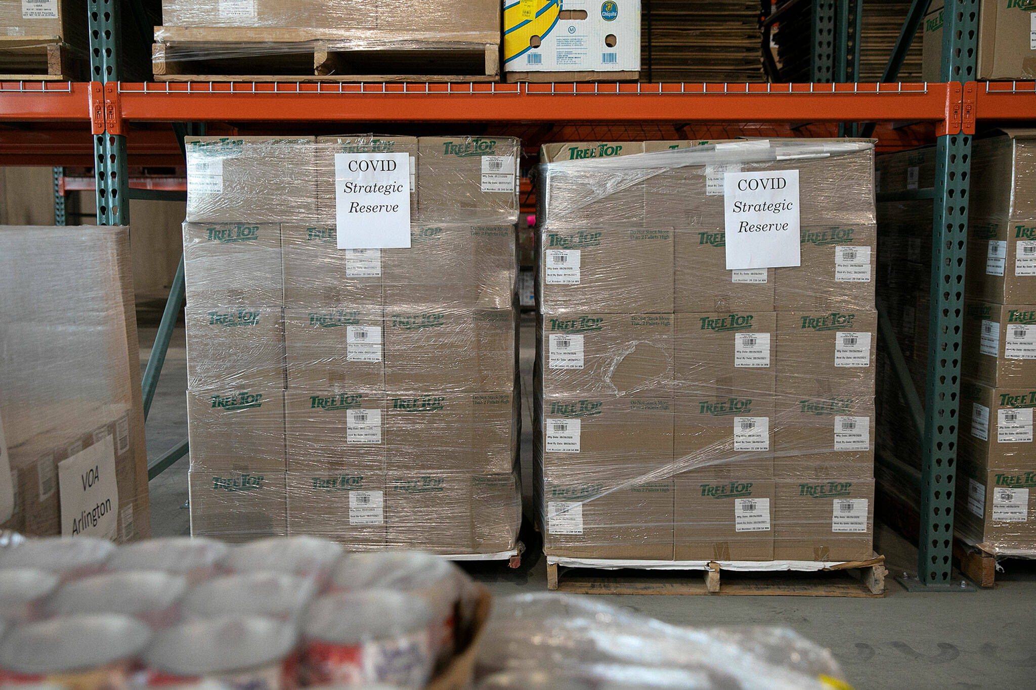 Boxes from the strategic COVID reserve are stored away in the warehouse Thursday, at the Volunteers of America food distribution center in Arlington.  (Ryan Berry/The Herald)