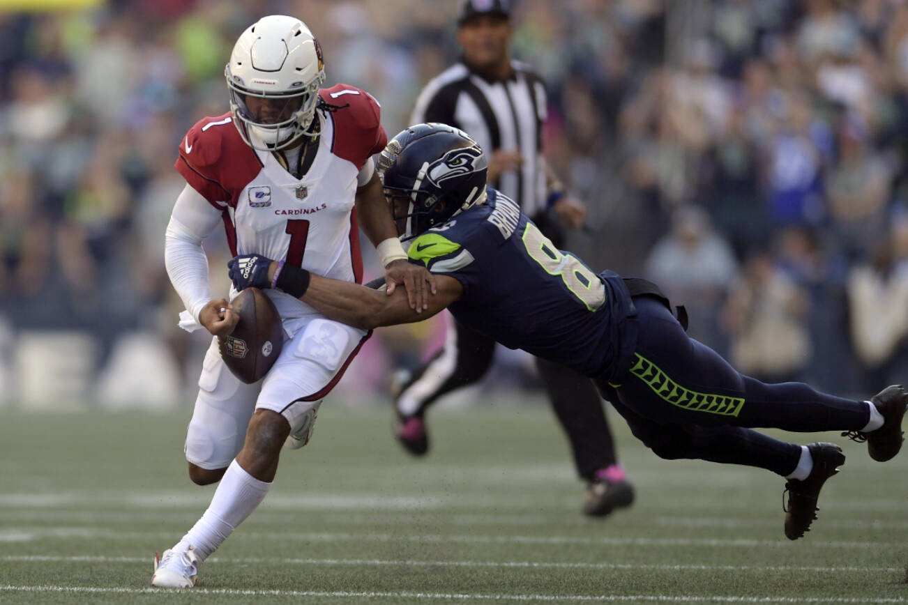 Arizona Cardinals quarterback Kyler Murray (1) fumbles while tackled by Seattle Seahawks cornerback Coby Bryant, right, during the second half of an NFL football game in Seattle, Sunday, Oct. 16, 2022. The ball was recovered by Seahawks cornerback Tariq Woolen. (AP Photo/Caean Couto)