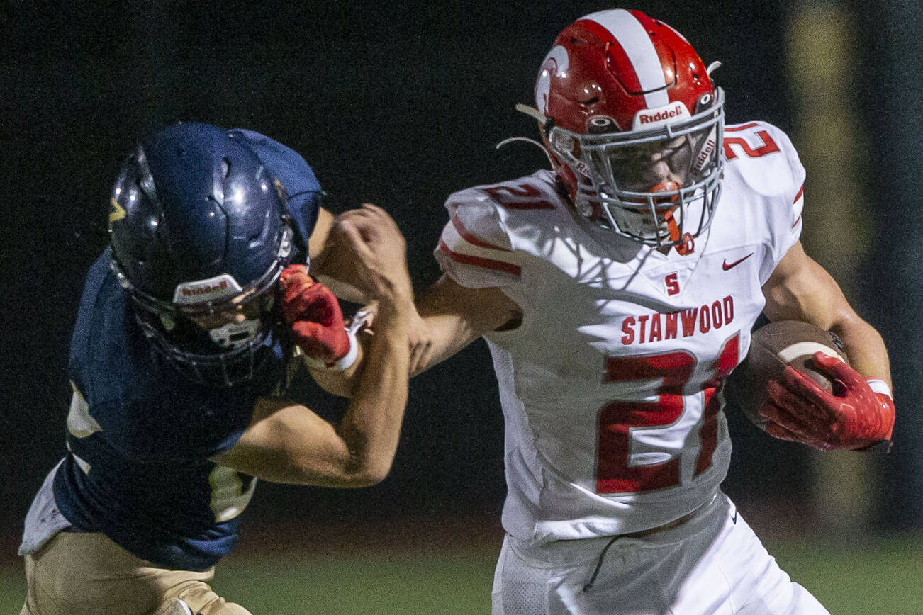 Stanwood’s Otto Wiedmann reacts out to block a tackle during the Stilly Cup against Arlington on Friday, Sept. 30, 2022 in Arlington, Washington. (Olivia Vanni / The Herald)