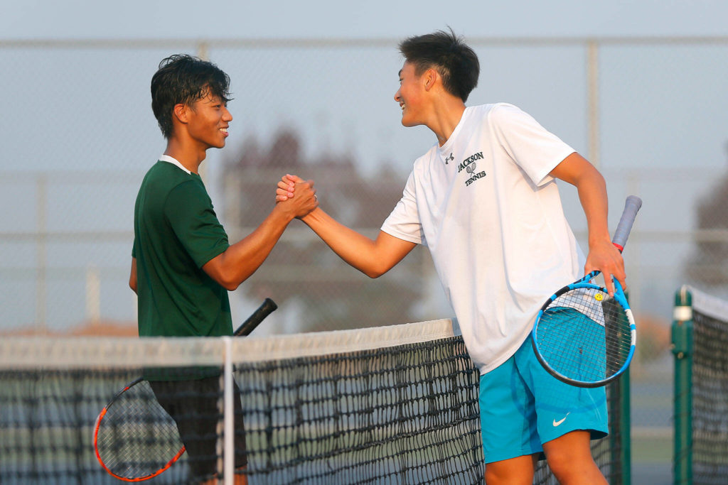 Lee (right) and senior teammate Austen Lim congratulate each other after the district singles final. (Ryan Berry / The Herald)
