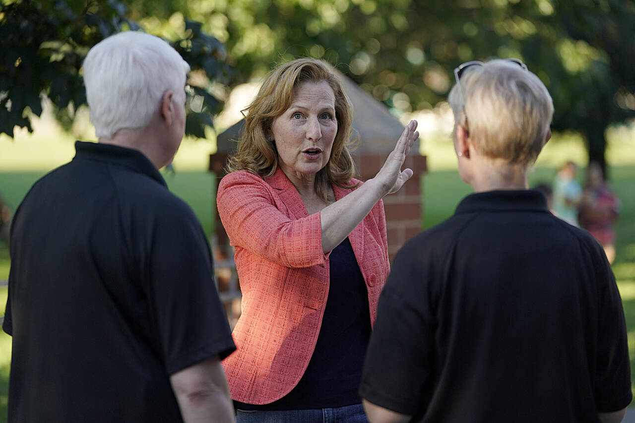 Rep. Kim Schrier, D-Wash., talks with officials from the Issaquah Police Department, Aug. 2, at a community event in Issaquah. Schrier, who represents Washington state’s 8th Congressional District, is facing Republican challenger Matt Larkin in the Nov. 8 general election. (Ted S. Warren / Associated Press)