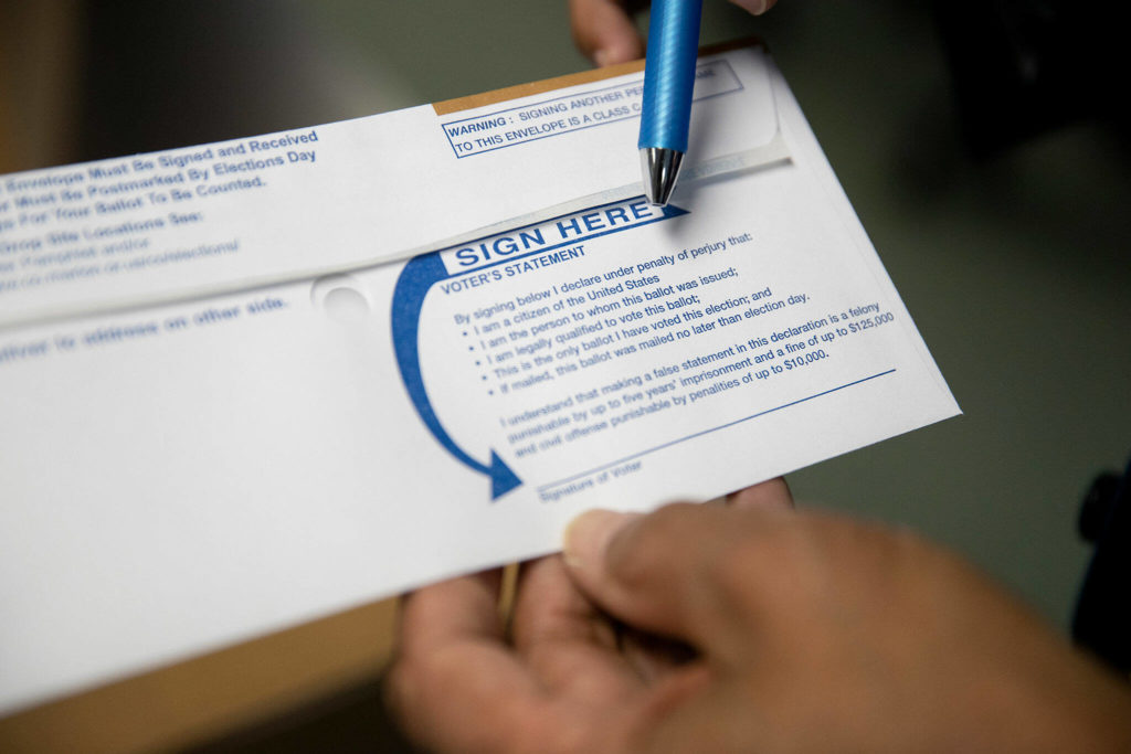 Bill Burgess, Marion County Clerk, points out a voter’s statement that each voter must sign before returning their ballot, on Sept. 28, at the Marion County Clerk’s Office. (Amanda Loman / InvestigateWest)

