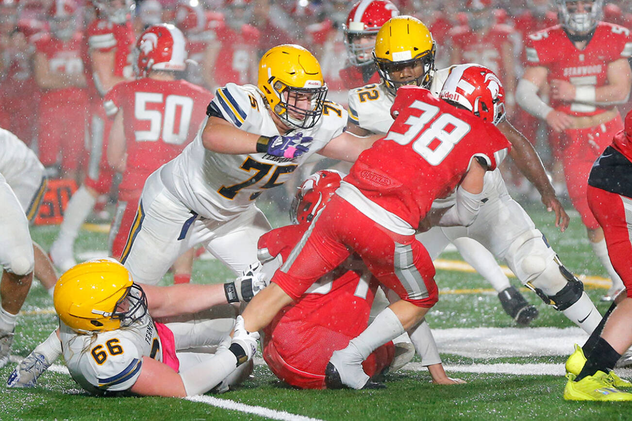 Stanwood’s Carson Beckt fights for extra yards as the rain comes down against Ferndale Friday, Oct. 21, 2022, at Stanwood High School in Stanwood, Washington. (Ryan Berry / The Herald)