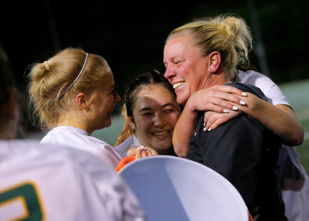Shorecrest head coach Mindy Dalziel is surrounded by her players after a water bath at the conclusion of their game against Shorewood on Monday, Oct. 24, 2022, at Shoreline Stadium in Shoreline (Ryan Berry / The Herald)

