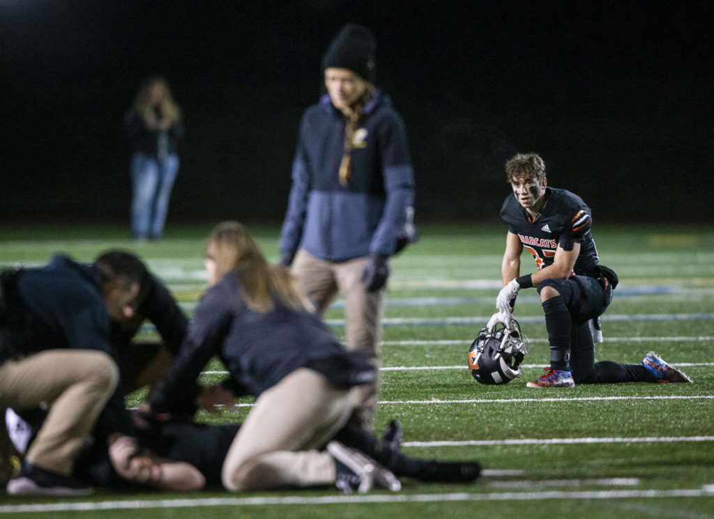 A Monroe player watches as his teammate gets evaluated for an injury during the game against Ferndale on Friday, Oct. 28, 2022 in Monroe, Washington. (Olivia Vanni / The Herald)
