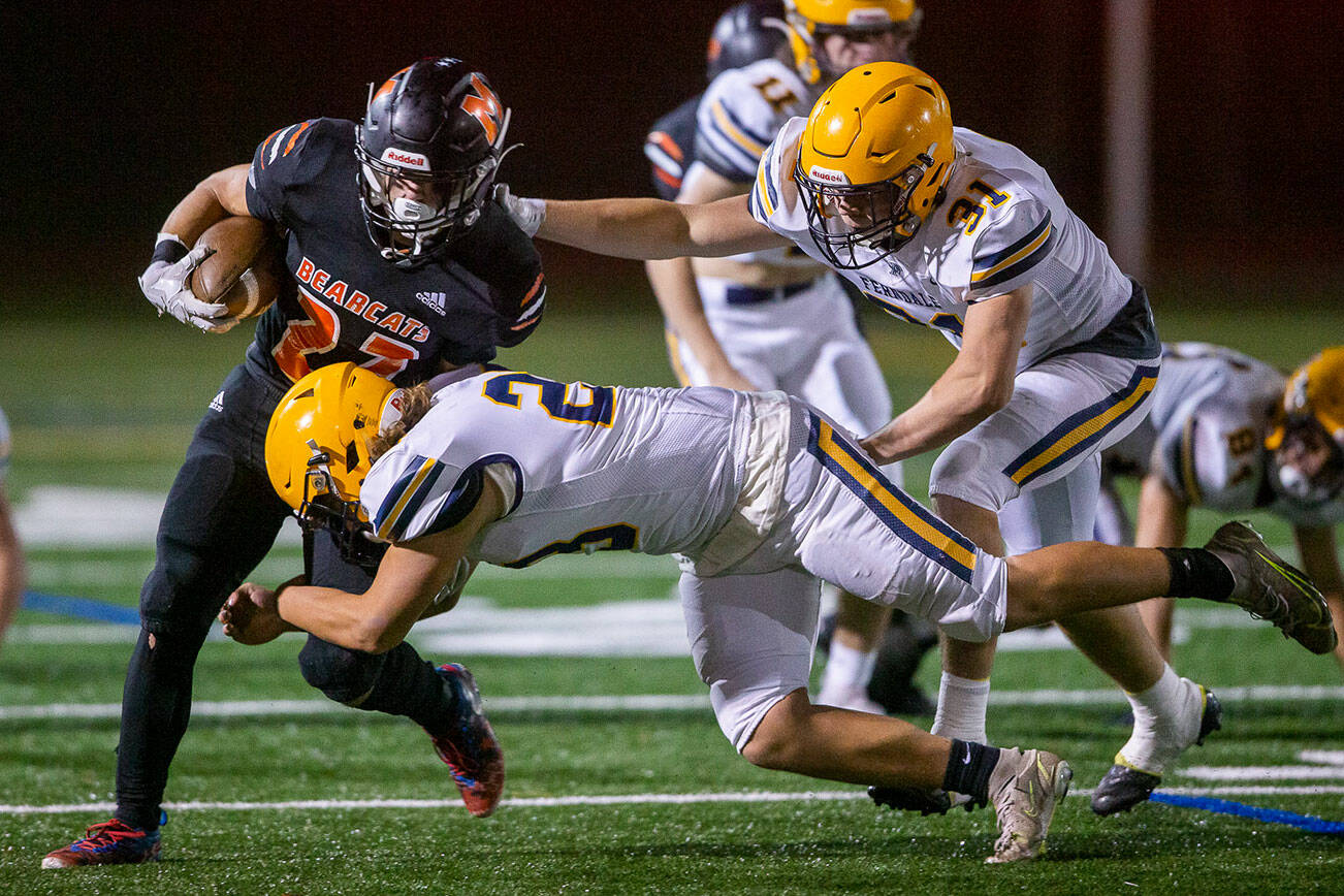 Monroe’s Jack Irwin escapes is tackled by multiple Ferndale players during the game on Friday, Oct. 28, 2022 in Monroe, Washington. (Olivia Vanni / The Herald)