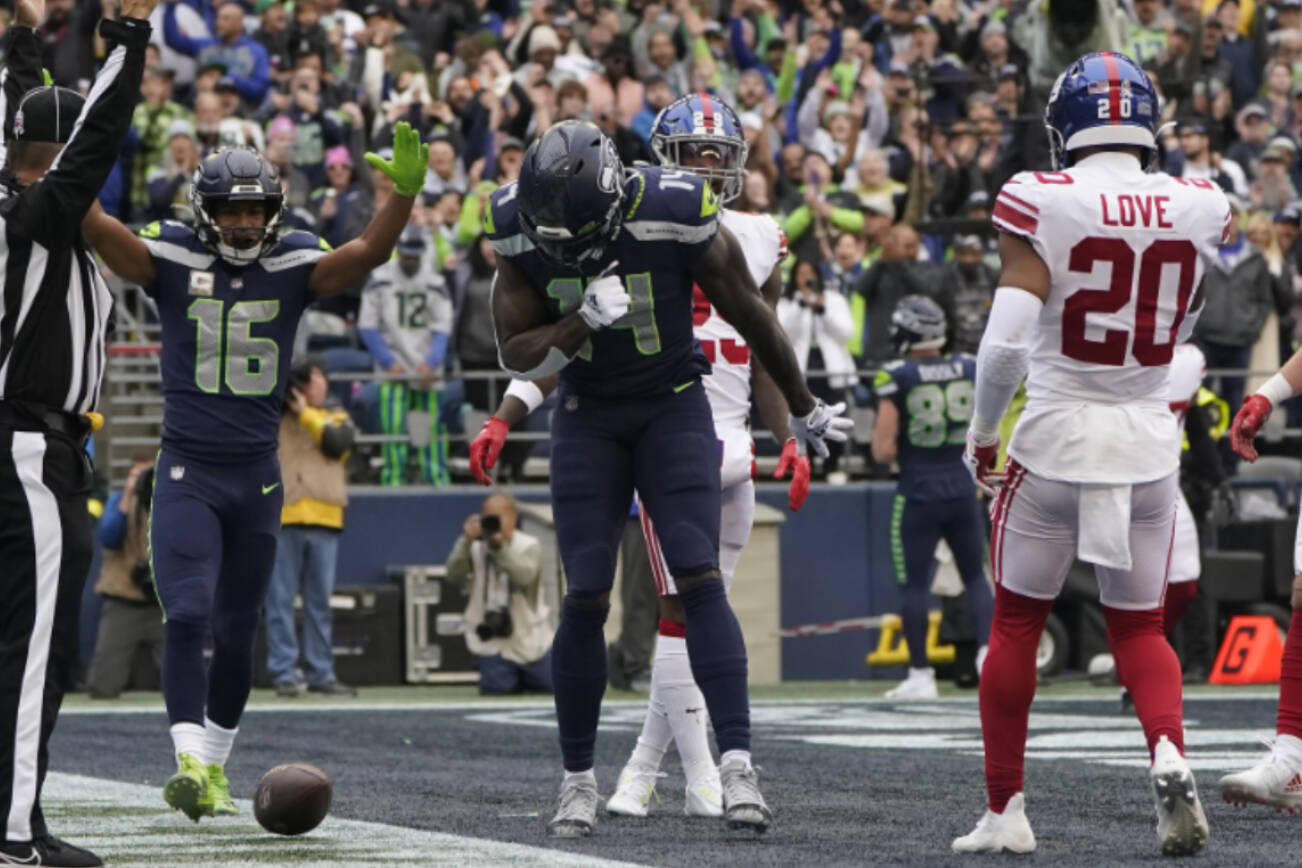 Seattle Seahawks wide receiver DK Metcalf, middle, celebrates after catching a touchdown pass between wide receiver Tyler Lockett (16) and New York Giants safety Julian Love (20) during the first half of an NFL football game in Seattle, Sunday, Oct. 30, 2022. (AP Photo/Marcio Jose Sanchez)