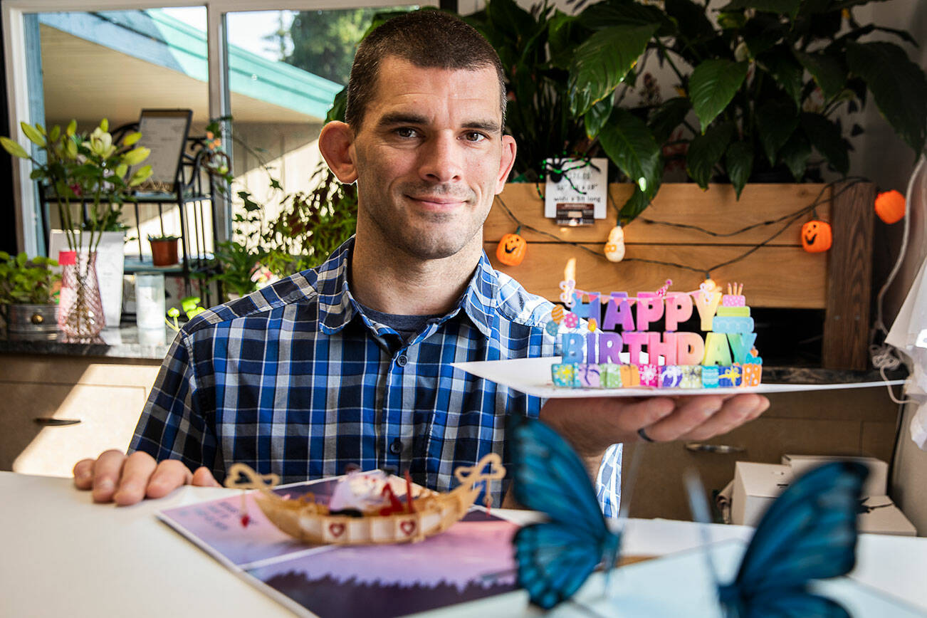 Andy Illyn with a selection of his greeting cards, Cardstalked, that are sold at What’s Bloomin’ Floral on Friday, Oct. 28, 2022 in Arlington, Washington. (Olivia Vanni / The Herald)