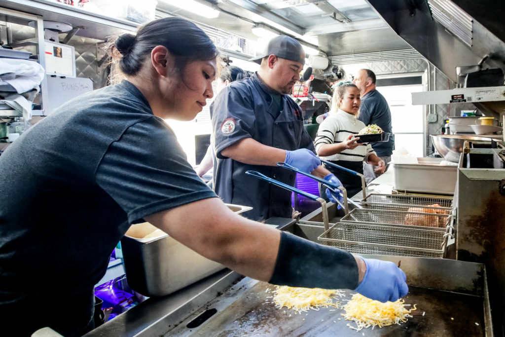From left, Elena Wilson, Ryan Gobin, Alice Tum and William Elliott work the line in Ryan’s REZ-ipes food truck. (Kevin Clark / The Herald)
