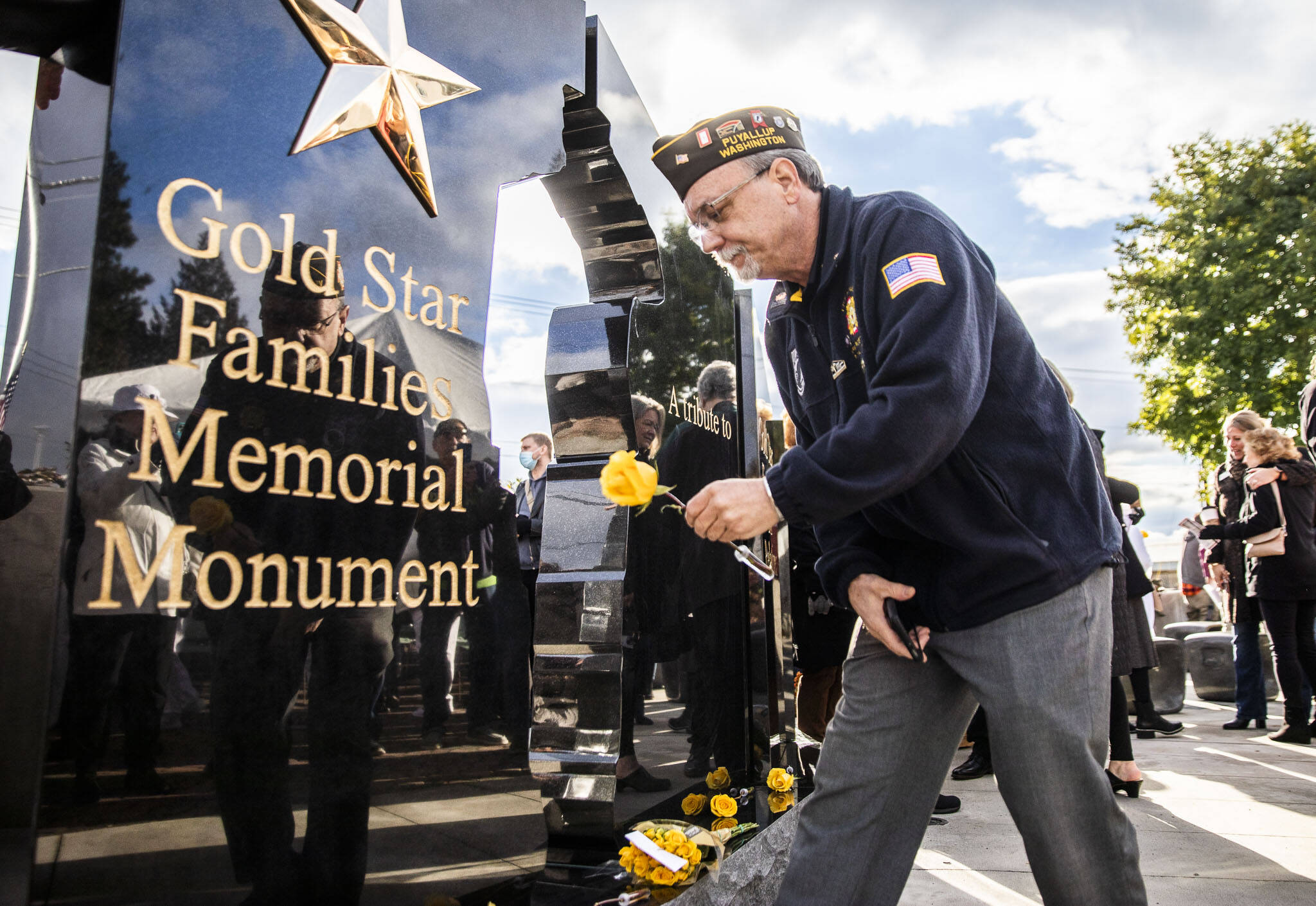 Air Force veteran Rick Holland places a yellow rose at the base of the new Gold Star Families Memorial Monument on Wednesday, in Lynnwood. (Olivia Vanni / The Herald)