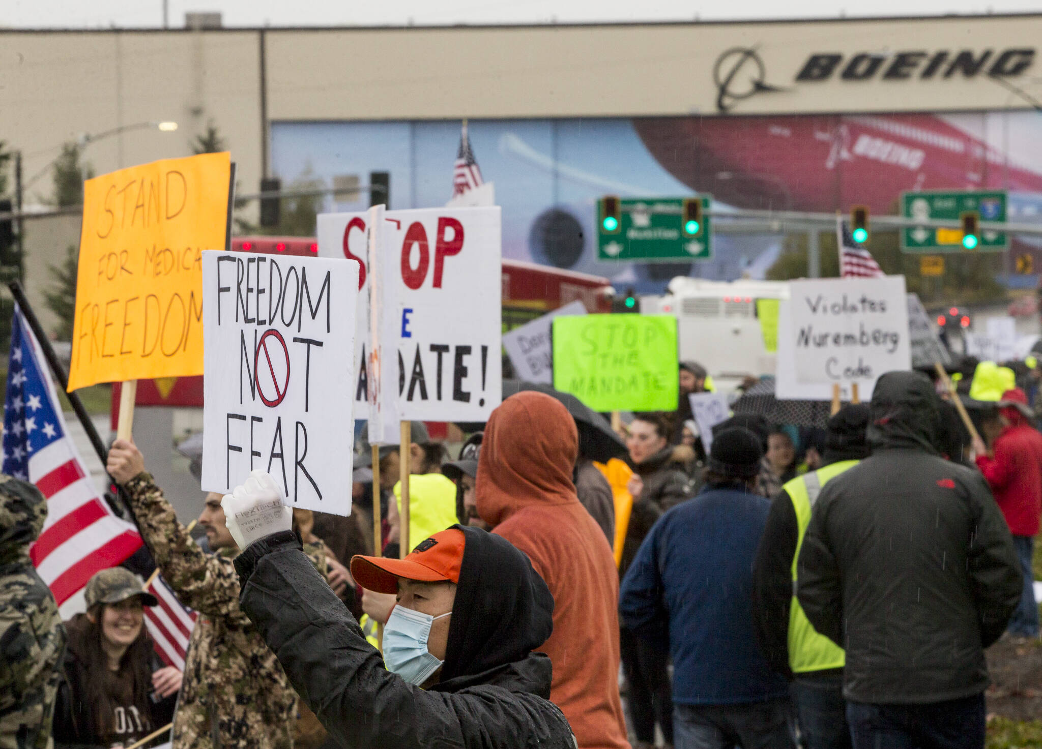 People hold signs in protest of the vaccine mandate after Boeing announced it would terminate workers who do not comply on Oct. 15, 2021, in Everett. (Olivia Vanni / The Herald)