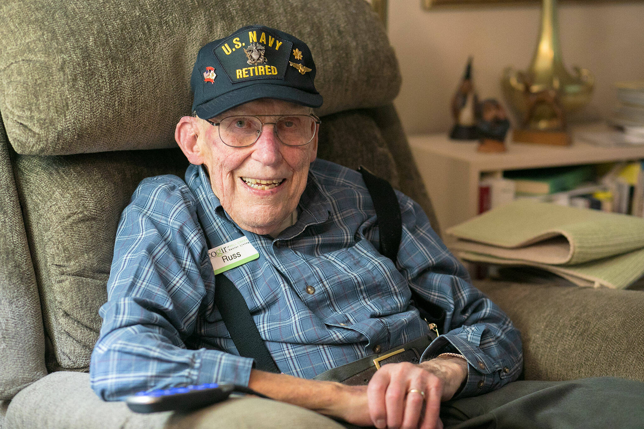 Russ Hupe, a 101-year-old veteran of the U.S. Navy, sits in his “big chair” on Nov. 3, at his home at Cogir Senior Living in Mill Creek. Hupe was Grand Marshal for Mill Creek’s Veterans Day ceremony this year. When asked if he ever anticipated being recognized for his service in WWII, he said with a laugh, “it wasn’t on my agenda.” (Ryan Berry / The Herald)
