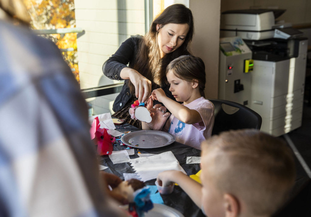 Anysia Snow, 6, and her mother Alex Snow work on decorating a sugar skull together during a free sugar skull making workshop at the Edmonds Library on Tuesday, in Edmonds. (Olivia Vanni / The Herald) 
