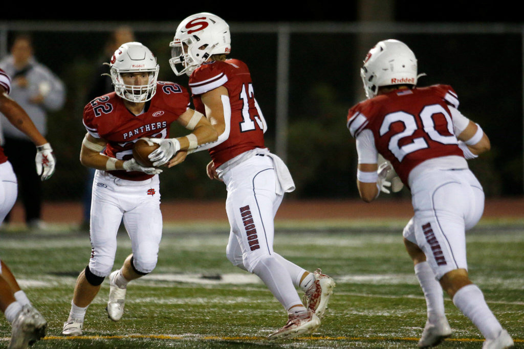 Snohomish’s Kale Hammer hands off to Kyle Larson at the start of a reverse play against Edmonds-Woodway Sept. 23 at Veterans Memorial Stadium in Snohomish. The Panthers travel to take on Bellevue on Friday. (Ryan Berry / The Herald)

