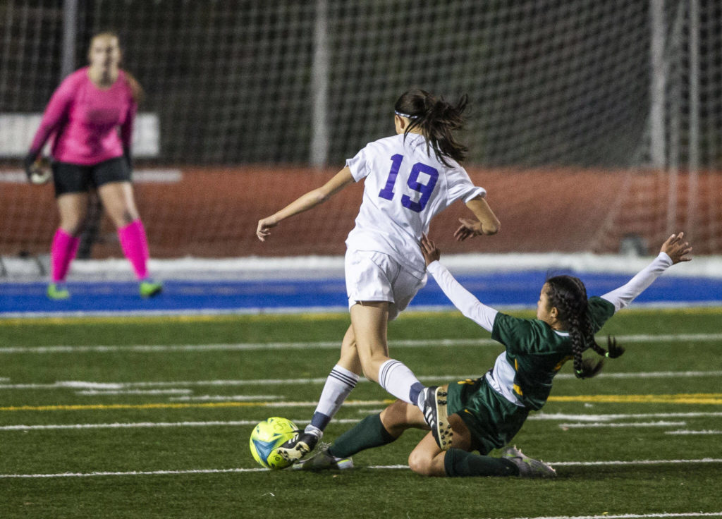 Shorecrest’s Tayvi Khann slide tackles Oak Harbor’s Madeline Mays during game on Tuesday, Nov. 1, 2022 in Shoreline, Washington. (Olivia Vanni / The Herald)
