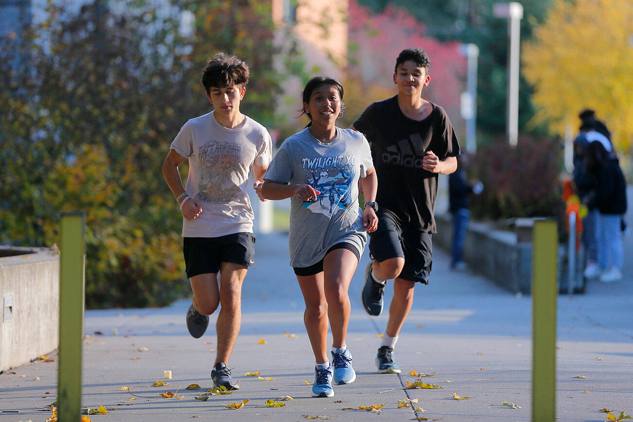 Marysville Getchell runner Marly Martinez finishes a cooldown run with junior Kealii Mooring and freshman Jaxsonn Gooding on Wednesday, Nov. 2, 2022, on their school’s campus in Marysville, Washington. (Ryan Berry / The Herald)