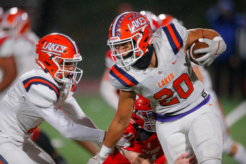 Lakes High School’s Leo Pulalasi tries to escape a tackle behind the line on a handoff against Stanwood on Friday, Nov. 4, 2022, at Stanwood High School in Stanwood, Washington. (Ryan Berry / The Herald)
