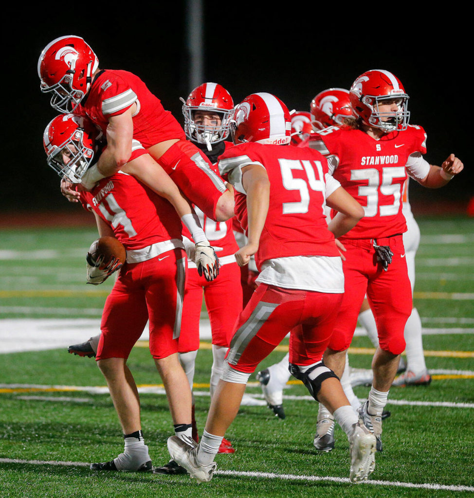 Stanwood’s Gary Grisham is swarmed by teammates after picking off a pass against Lakes High School on Friday, Nov. 4, 2022, at Stanwood High School in Stanwood, Washington. (Ryan Berry / The Herald)
