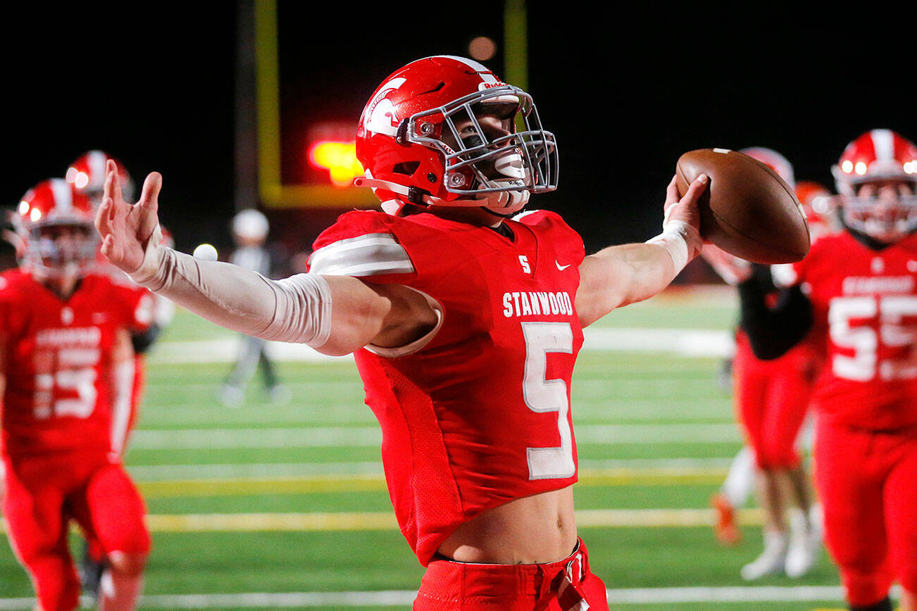 Stanwood senior running back Ryder Bumgarner celebrates after taking a handoff in for a touchdown during the first half against Lakes High School on Friday, Nov. 4, 2022, at Stanwood High School in Stanwood, Washington. (Ryan Berry / The Herald)