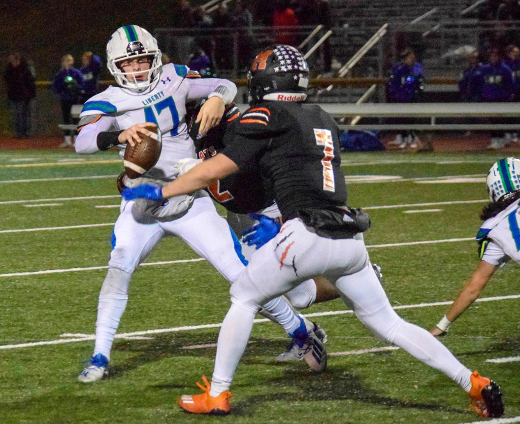 Monroe Seniors Stevie Khunle and Kody Edelbrock sack Liberty quarterback Rohne Klein on Friday, Nov. 4, 2022 in Monroe, Washington. (Katie Webber / The Herald)
