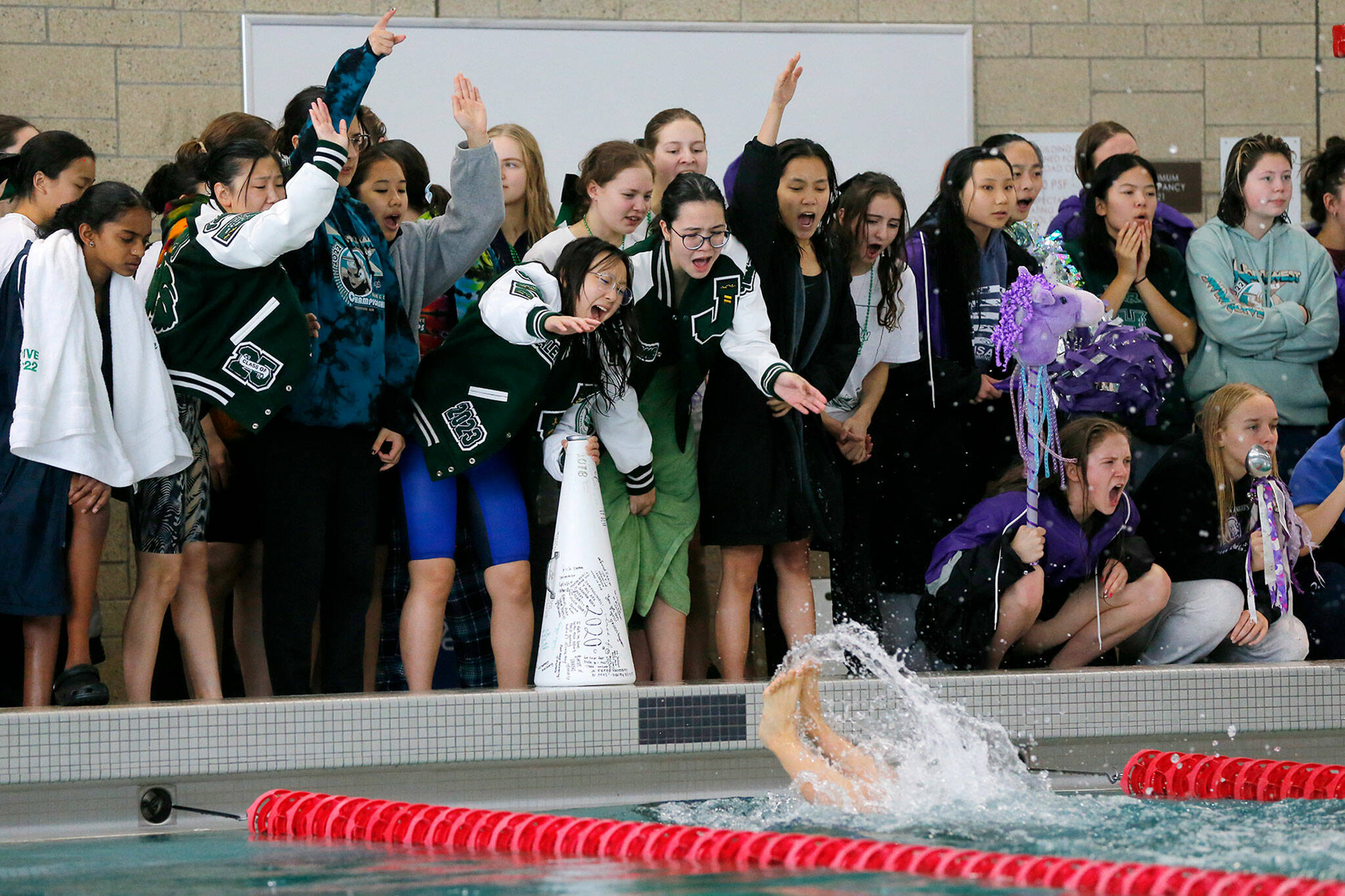 The Jackson girls cheer on their swimmers during the400 yard freestyle relay at the Class 4A District 1 swim meet Saturday, Nov. 5, 2022, at Snohomish Aquatic Center in Snohomish, Washington. (Ryan Berry / The Herald)