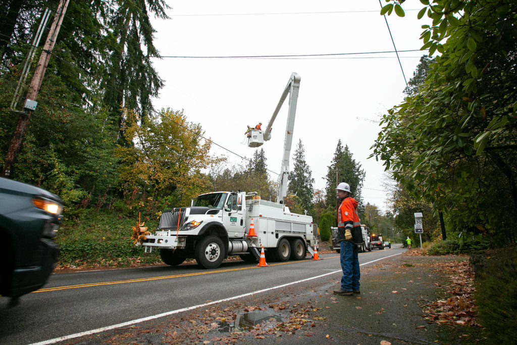 A Snohomish County PUD line crew works to fix power lines and restore electricity to a neighborhood along North Davies Road on Monday in Lake Stevens. (Ryan Berry / The Herald)
