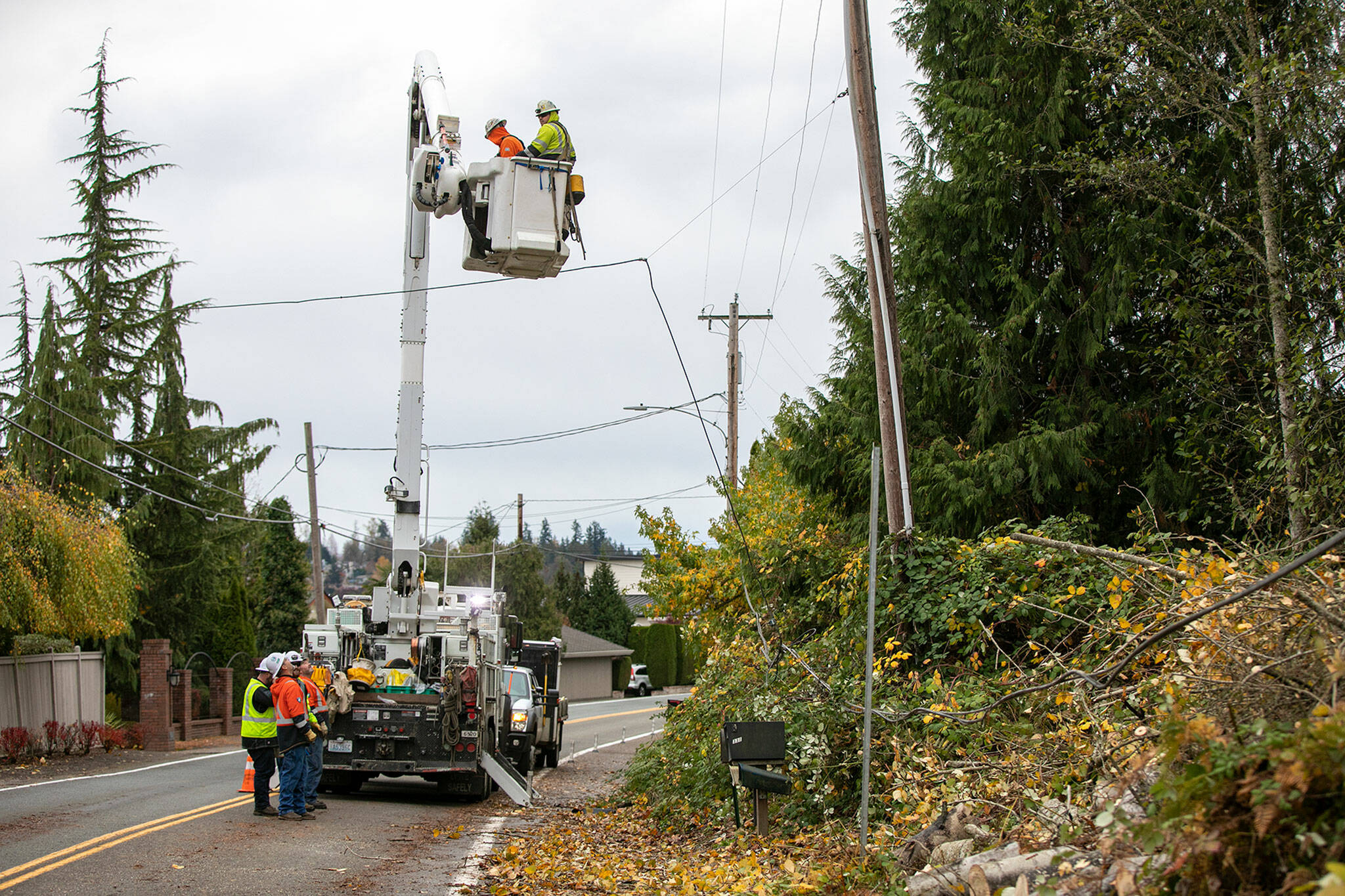A Snohomish County PUD line crew works to fix power lines and restore electricity to a neighborhood along North Davies Road on Monday, in Lake Stevens. (Ryan Berry / The Herald)
