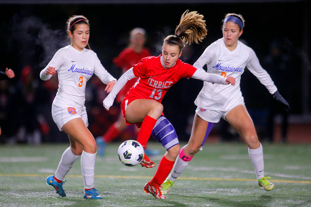 Mountlake Terrace’s Natalie Cardin keeps the ball away from Auburn Mountainview’s Lucy Montiel and Kamryn Kuolt during a first round game in the 3A State Tournament on Wednesday, Nov. 9, 2022, Edmonds District Stadium in Edmonds, Washington. (Ryan Berry / The Herald)