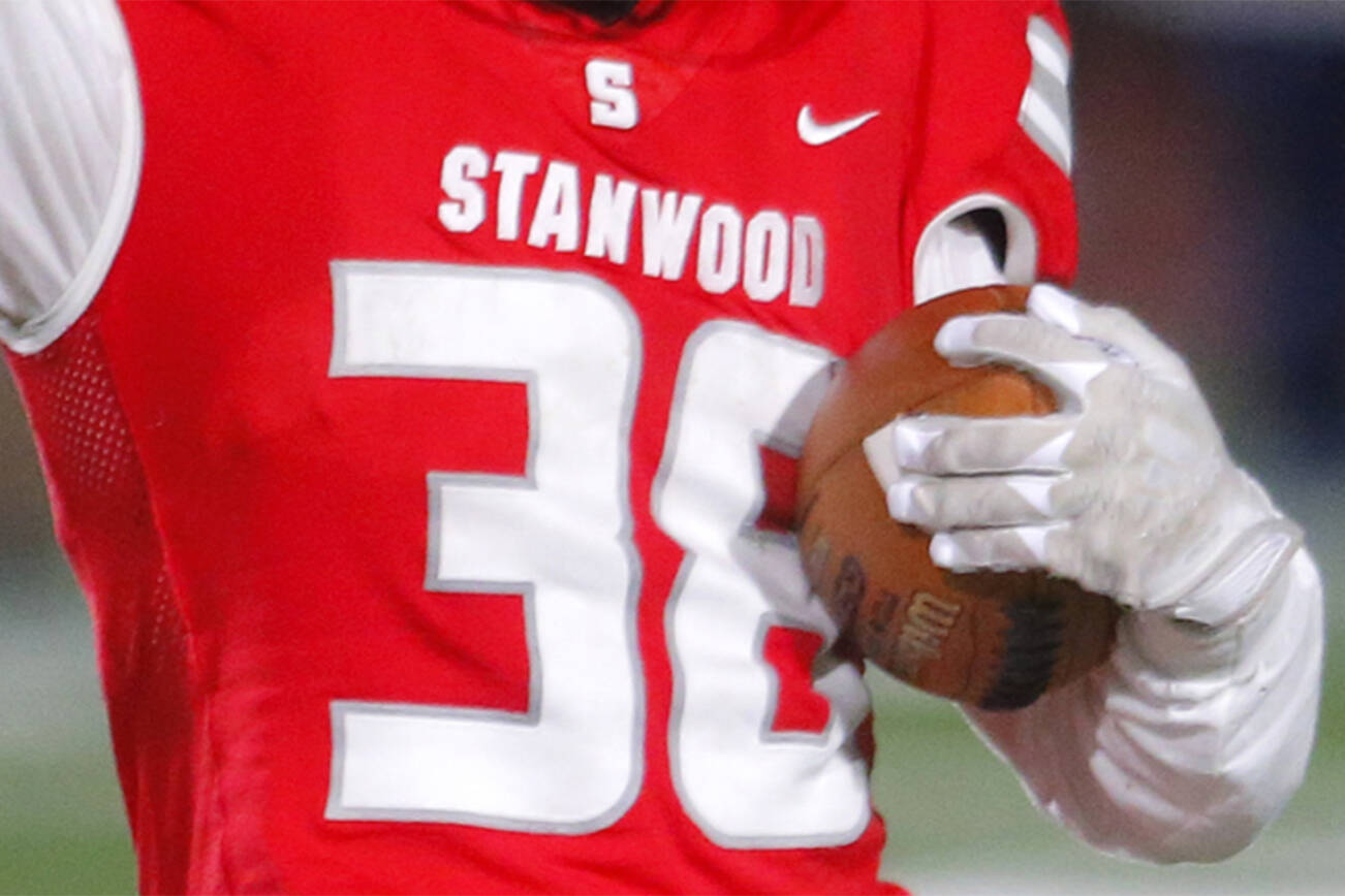 Stanwood’s Carson Beckt signals for a first down after holding onto a pass through hard contact against Lakes High School on Friday, Nov. 4, 2022, at Stanwood High School in Stanwood, Washington. Targeting was called on the play, resulting in extra yards for Stanwood. (Ryan Berry / The Herald)