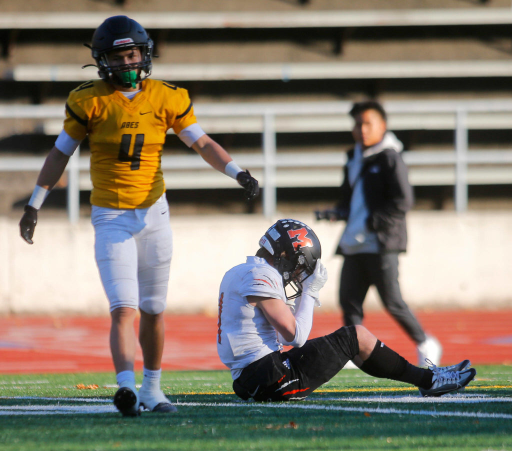 Monroe’s Mason Davis holds his head after getting hit hard during a playoff matchup against Lincoln High on Saturday, Nov. 12, 2022, at the Lincoln Bowl in Tacoma, Washington. (Ryan Berry / The Herald)
