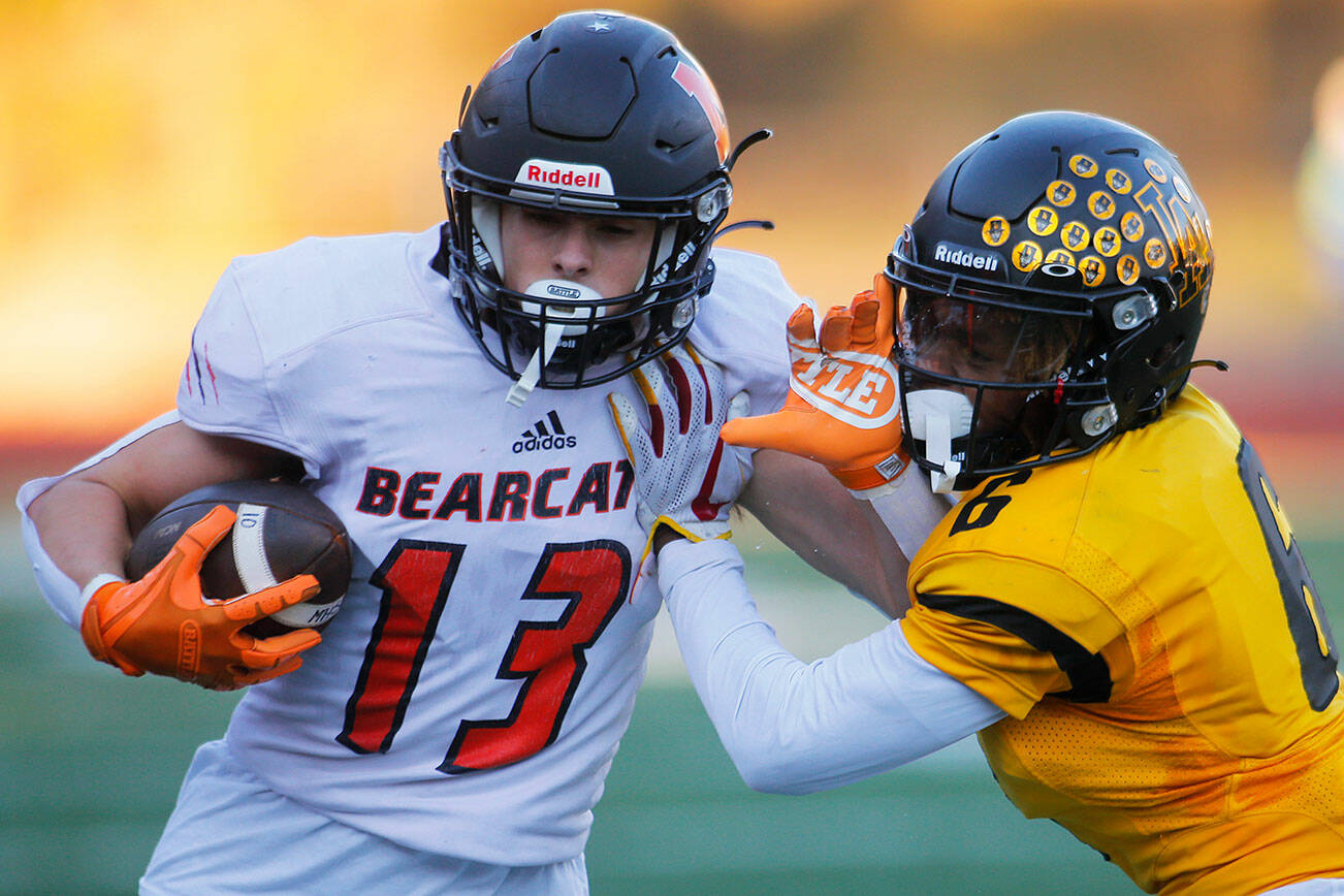 Monroe’s Eli Miller stiff arms a defender while being pushed out of bounds during a playoff matchup against Lincoln High on Saturday, Nov. 12, 2022, at the Lincoln Bowl in Tacoma, Washington. (Ryan Berry / The Herald)