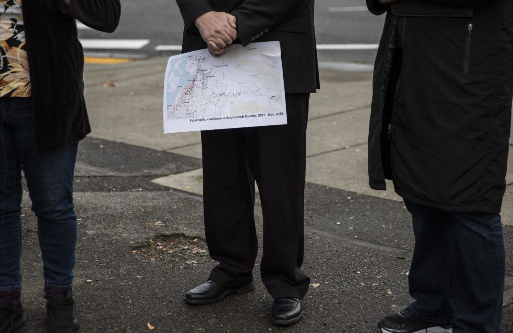 Lynnwood City Council member George Hurst holds a map marking fatal traffic collisions in Snohomish County since 2013 during a press conference for World Day of Remembrance for Road Traffic Victims on Monday in Everett. (Olivia Vanni / The Herald)
