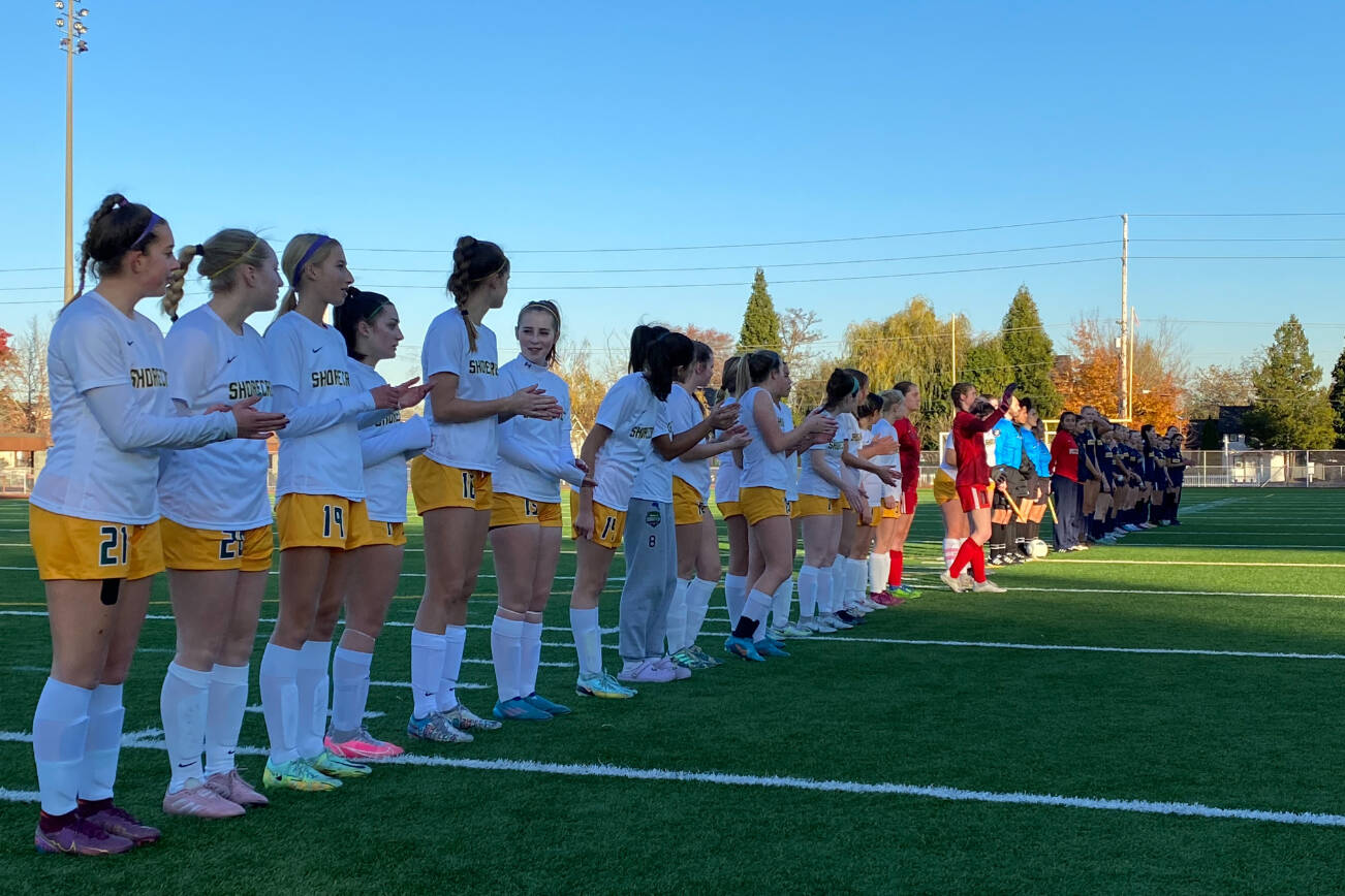 The Shorecrest and Bellevue girls soccer teams line up on the field before a 3A state semifinal match on Nov. 18, 2022, at Sparks Stadium in Puyallup. (Nick Patterson / The Herald)