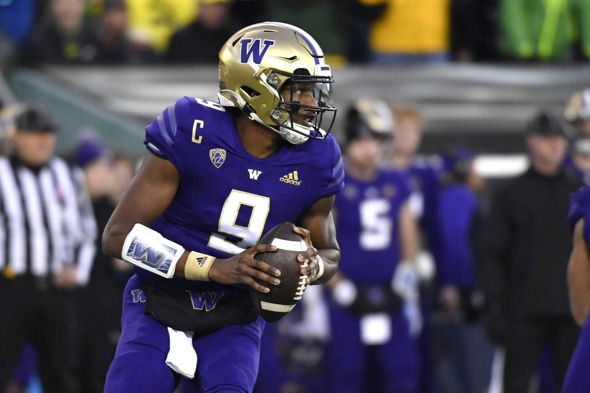 Washington quarterback Michael Penix Jr. (9) rolls away from Oregon defenders and looks for a receiver during the first half of a game Nov. 12 in Eugene, Ore. (AP Photo/Andy Nelson)