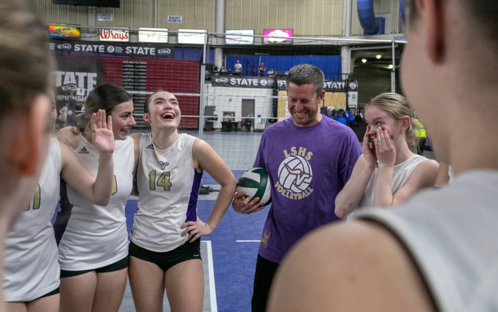 Head coach Kyle Hoglund and the Lake Stevens team laugh through tears after falling to Graham-Kapowsin in the 4A state volleyball championship match on Saturday at the Yakima Valley SunDome. Lake Stevens finished in second place. (TJ Mullinax / For The Herald)
