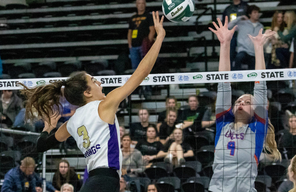 Lake Stevens’ Laura Eichert (3) hits over Graham-Kapowsin’s Grace Peterson during the WIAA state volleyball championship on Saturday, Nov. 19, 2022, at the Yakima Valley SunDome in Yakima. (TJ Mullinax/ For The Herald)
