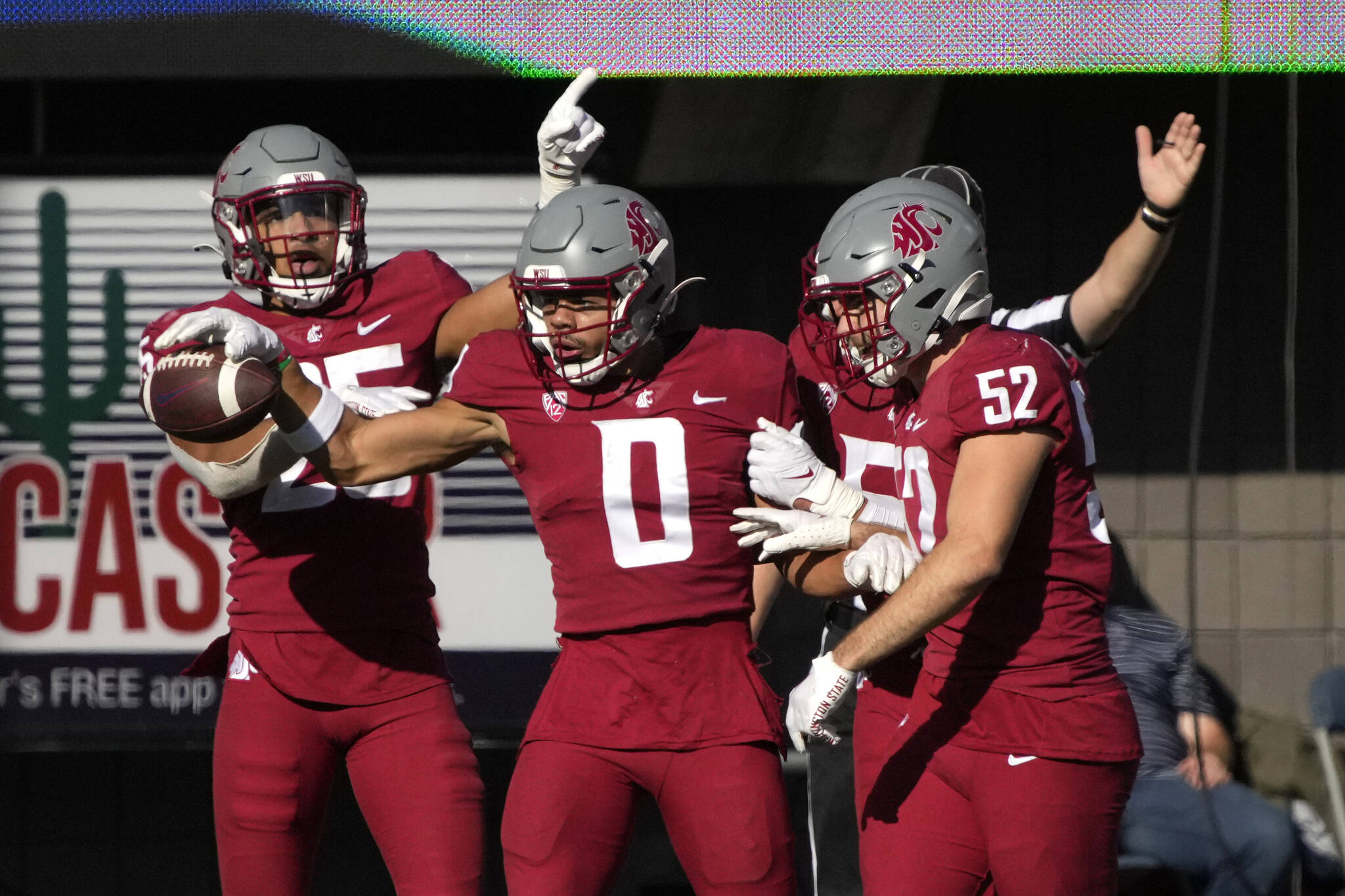 Washington State defensive back Sam Lockett III (0) celebrates with Jaden Hicks and Kyle Thornton (52) after making an interception against Arizona during the second half of a game Saturday in Tucson, Ariz. (AP Photo/Rick Scuteri)